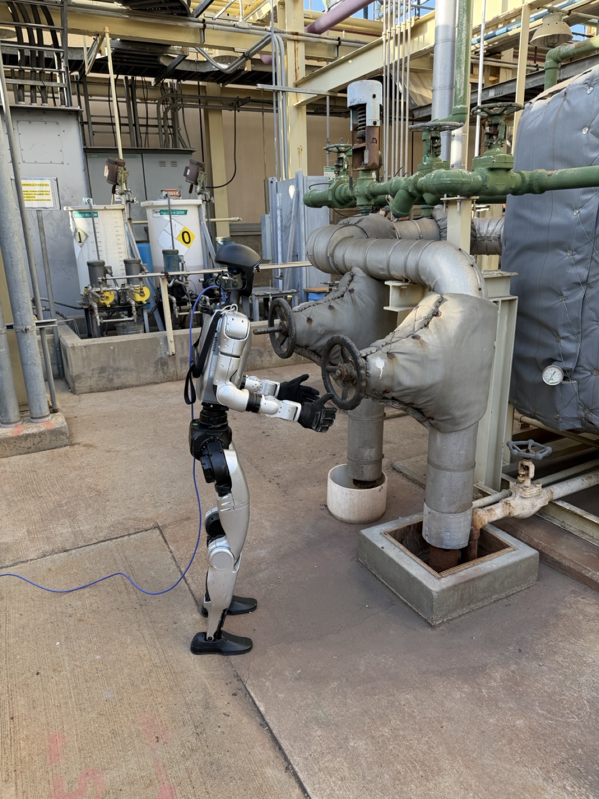 A humanoid robot operating a valve wheel in a power plant